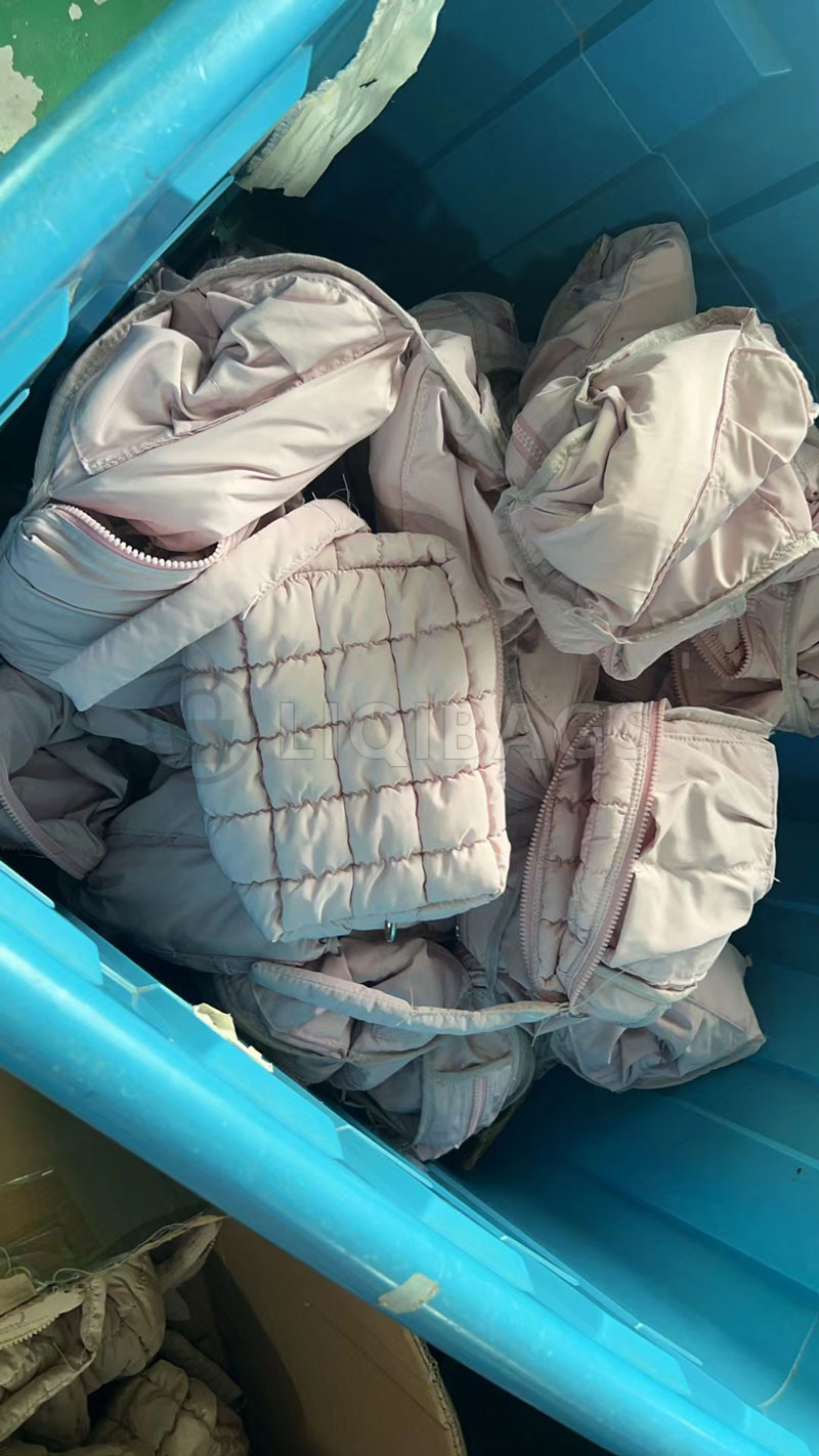 Pale pink quilted zip pouches in a production batch, showing pouch shape and open zippers